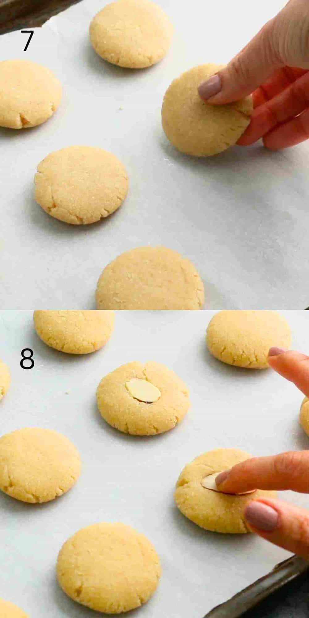 a hand placing a shaped cookies on a parchment lined baking sheet.