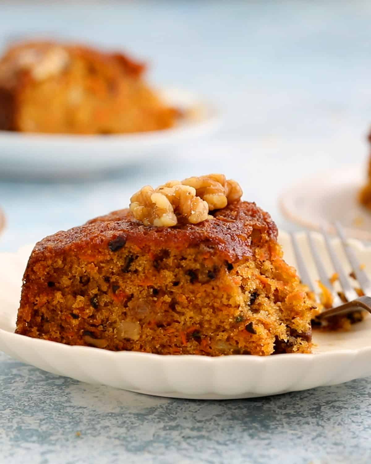 one slice of carrot cake placed on a white plate.