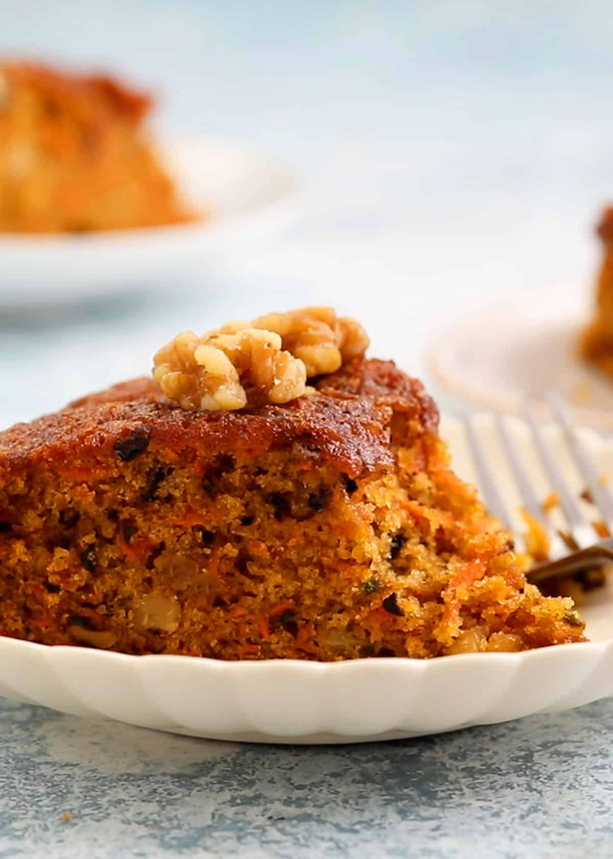 one slice of carrot cake placed on a white plate.