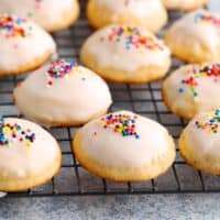 white ricotta cookies topped with sprinkles placed on a wire rack.