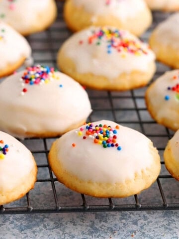 white ricotta cookies topped with sprinkles placed on a wire rack.