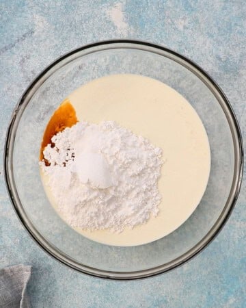 white cream and powdered sugar in a large glass bowl.