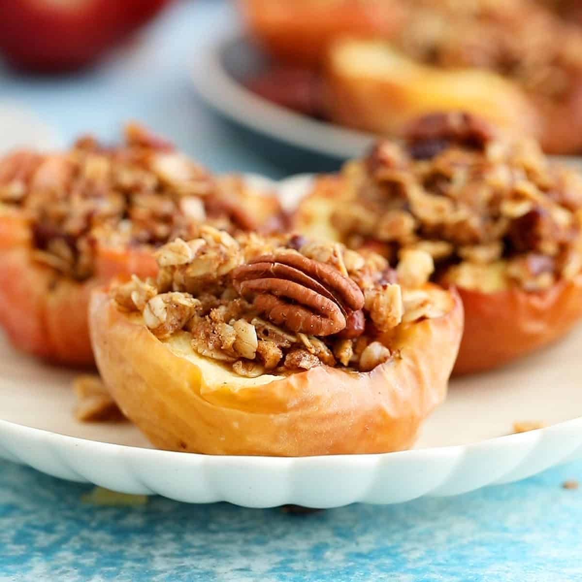 3 air fried apple halves in a white plate.