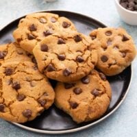 6 chocolate chip cookies on a round black plate.