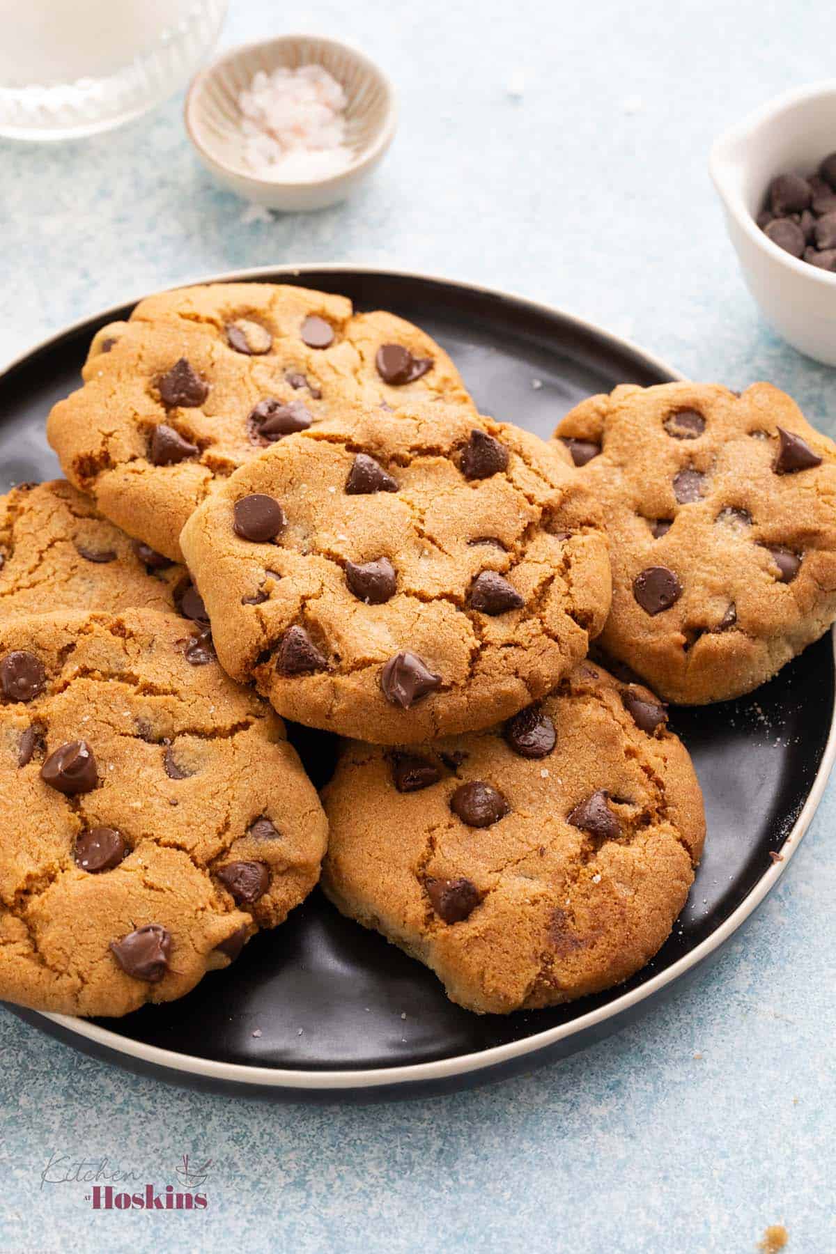 6 chocolate chip cookies on a round black plate.