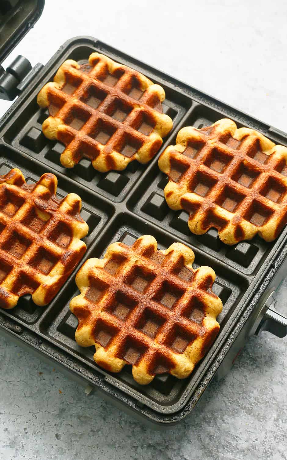 cooked waffles on a waffle iron.