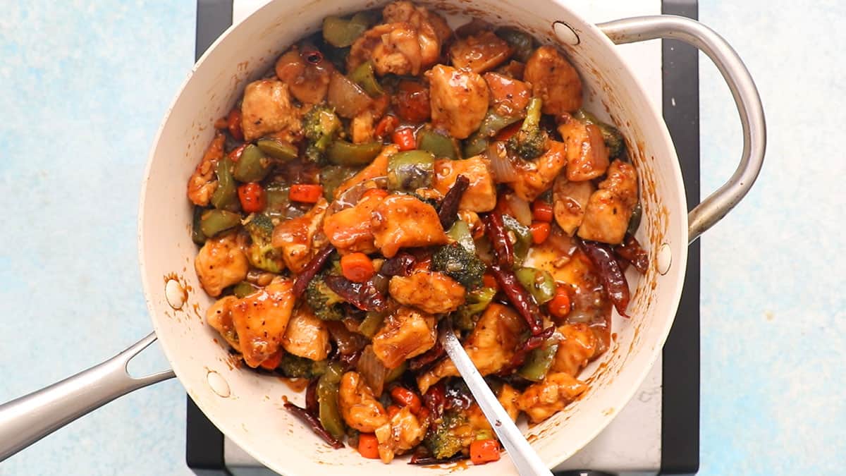 Hunan chicken with vegetables in a white pan.