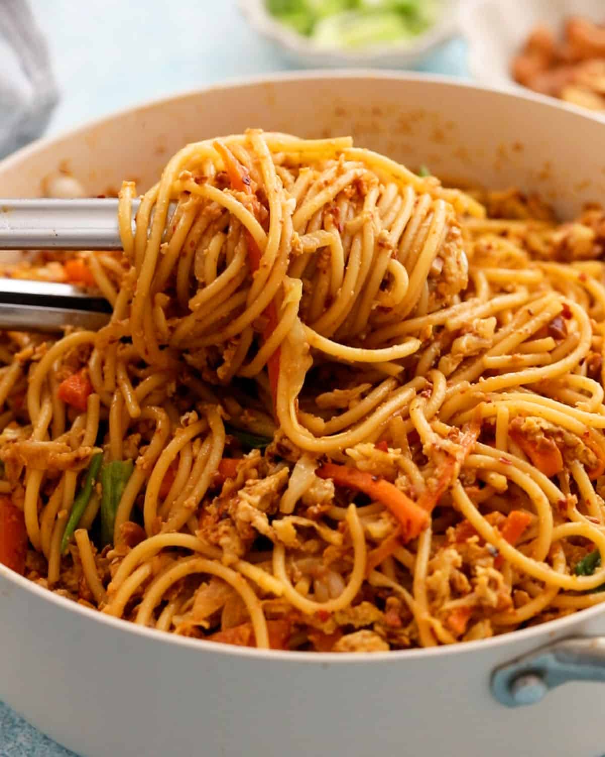 spicy thai noodles in a white pan.