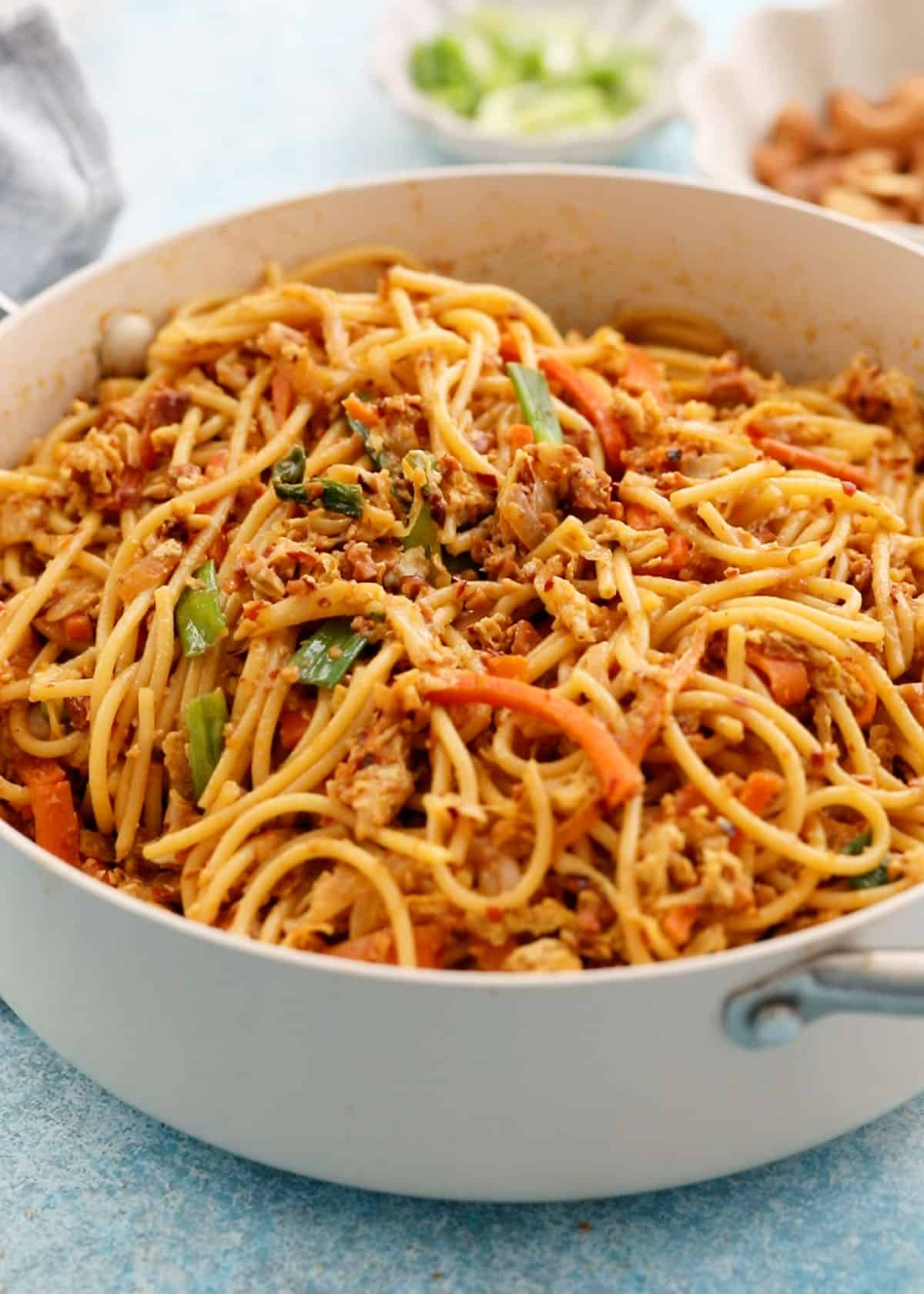 spicy thai noodles in a white pan.