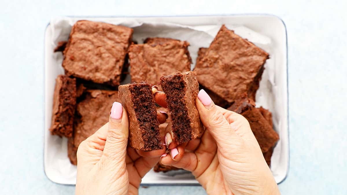 two hands breaking one brownie.