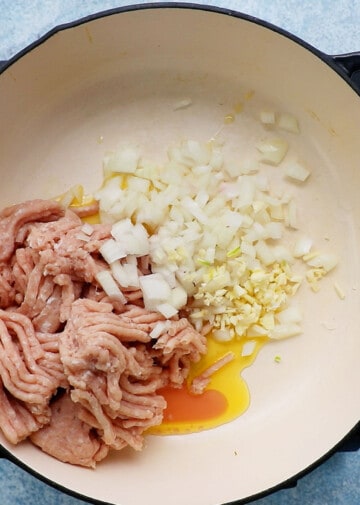 ground chicken, onion and garlic in a white skillet.
