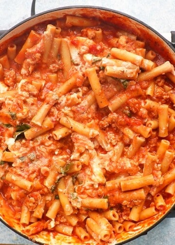 cooked ziti pasta along with ricotta and red sauce in a large pan.