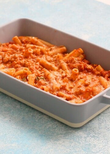 cooked red ziti pasta in a rectangular grey baking dish. 