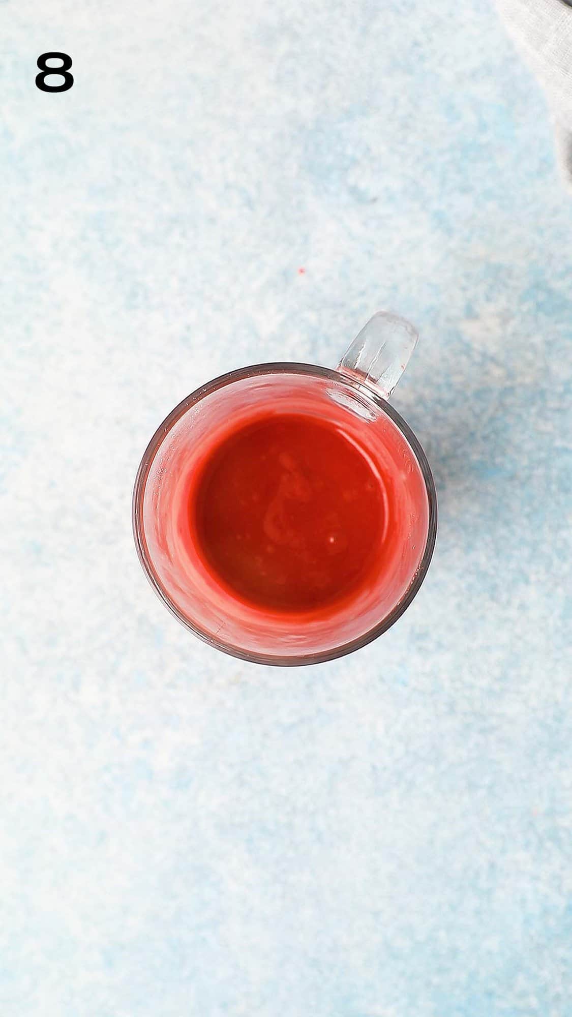 a glass mug with red velvet cake batter.