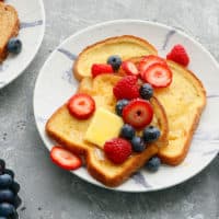 white plates with air fried french toast topped with butter and berries