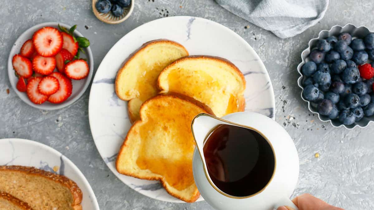 pouring maple syrup over french toast made in air fryer
