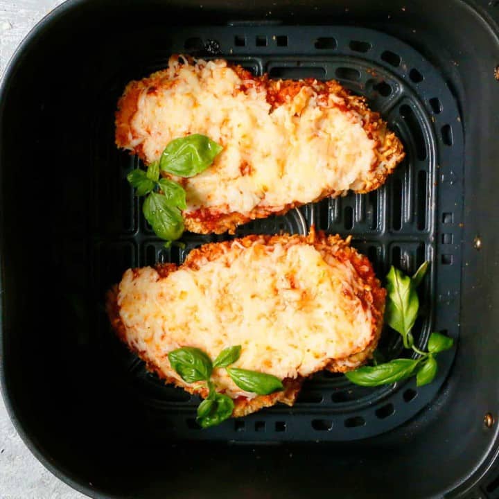 an air fryer basket with chicken parmesan
