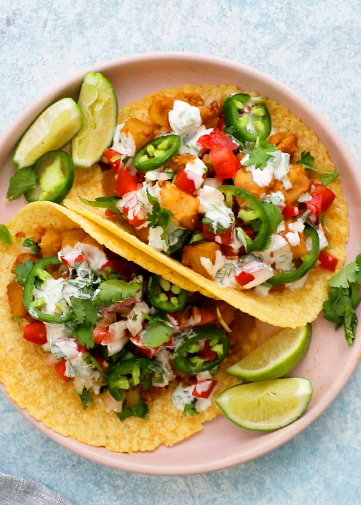 2 potato tacos topped with cilantro lime sauce.