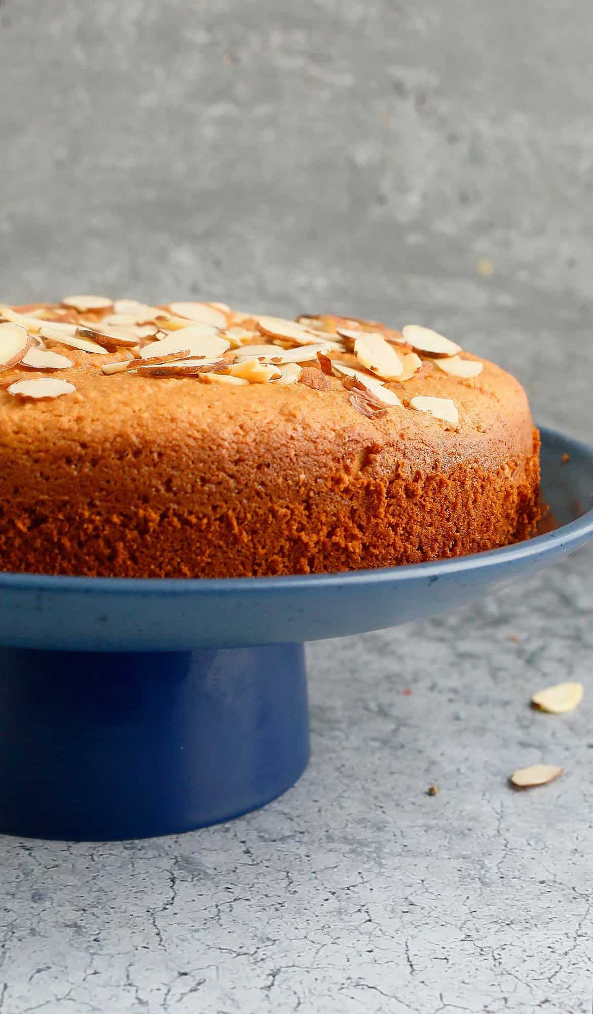 Gluten free almond cake placed on a blue cake stand