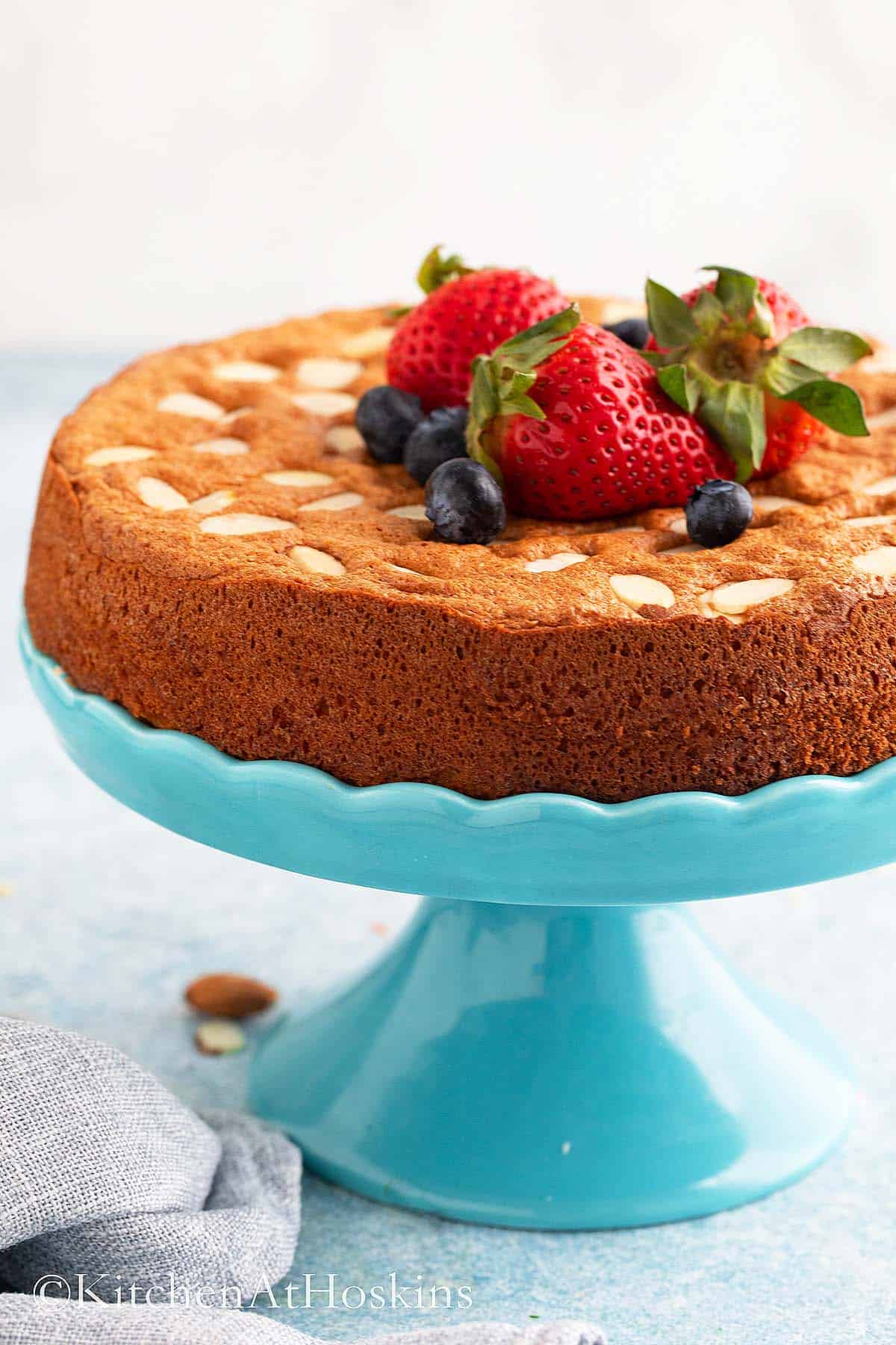 one almond flour cake on a blue cake stand.