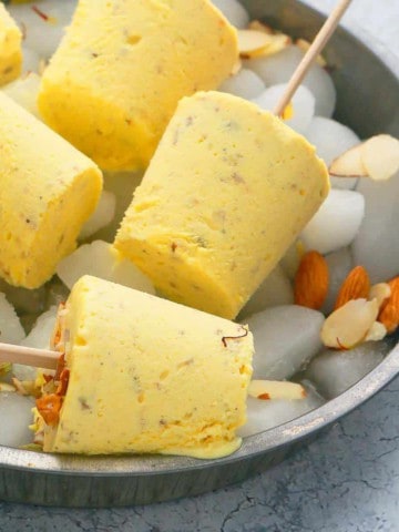 Badam Kulfi placed on a tray filled with ice