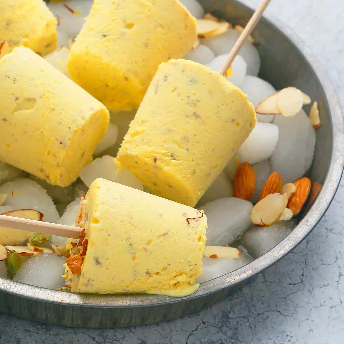 Badam Kulfi placed on a tray filled with ice