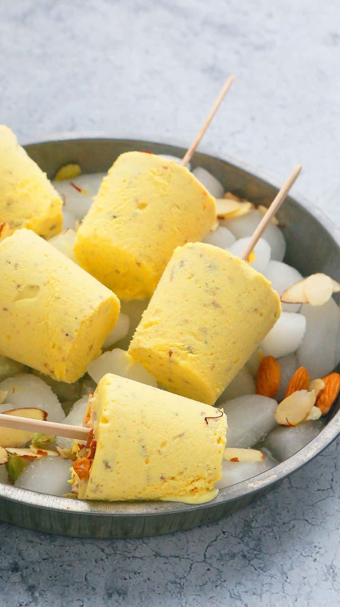 metal tray with almond kulfi placed over ice