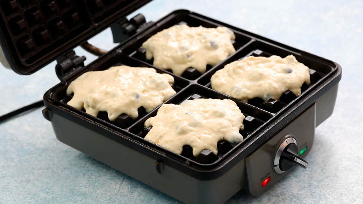 a waffle maker with waffle batter.