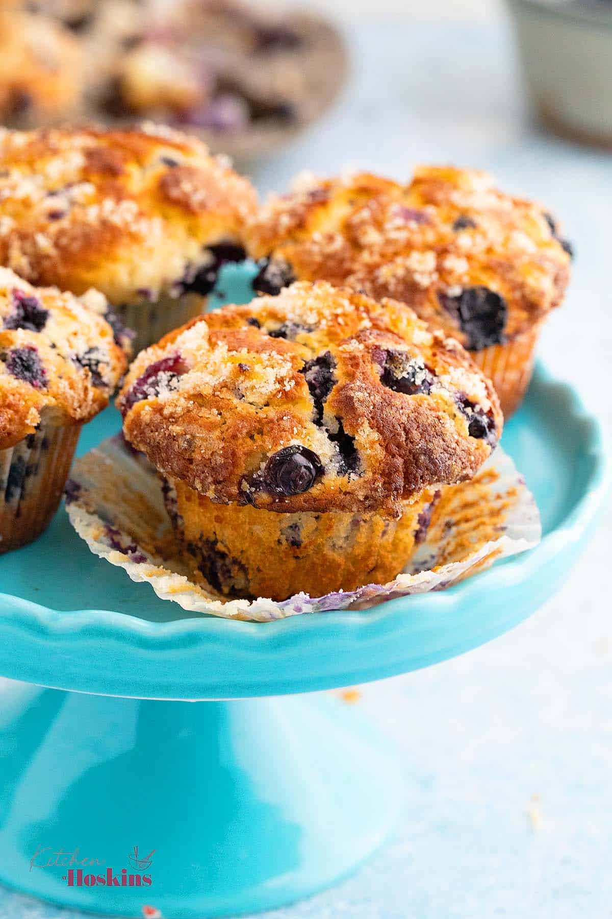 one blue cake stand with 4 blueberry muffins,