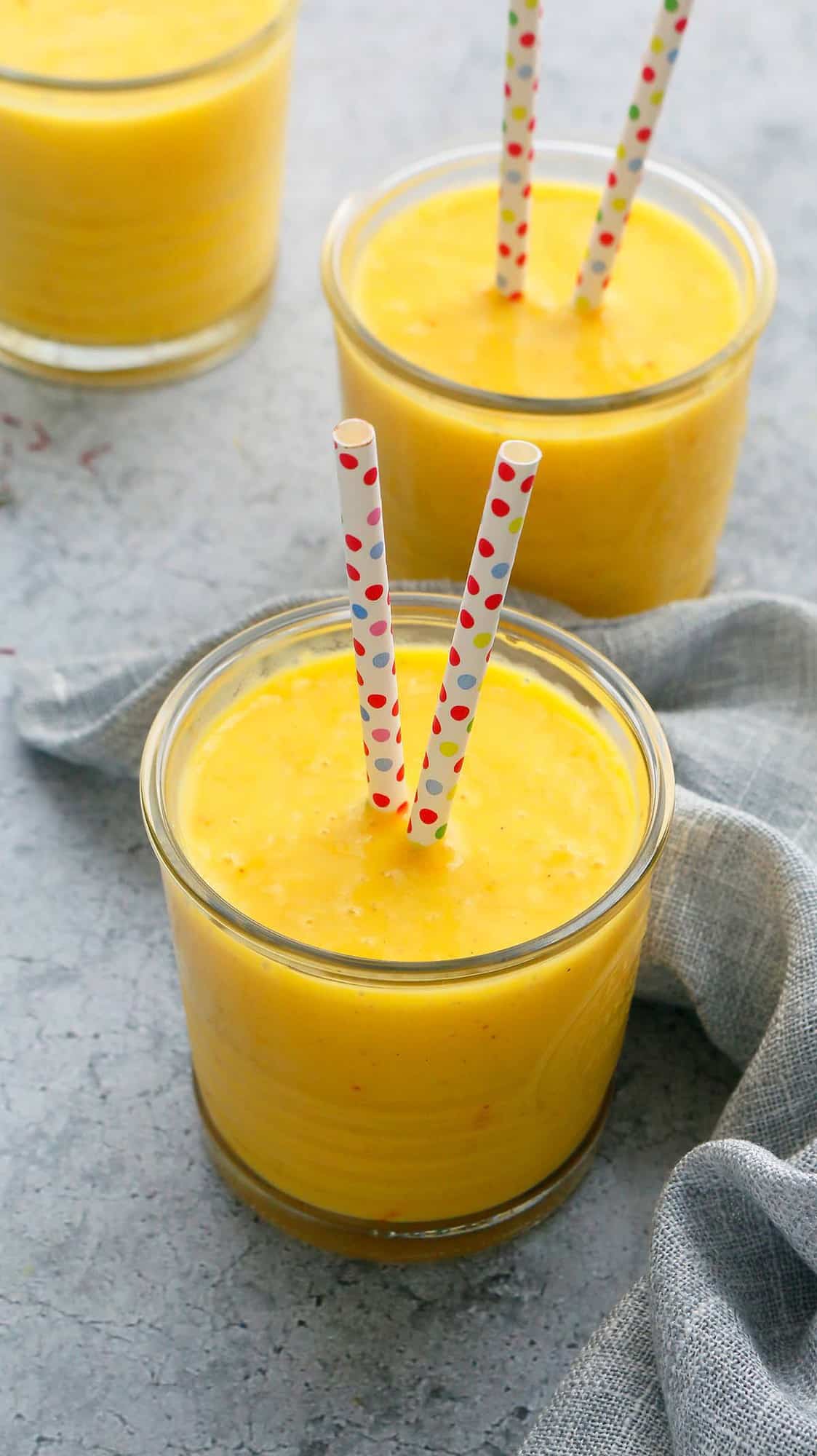 mango and milk served in glasses with paper straws