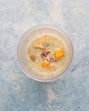 all ingredients needed to amke mango milk in a blender.