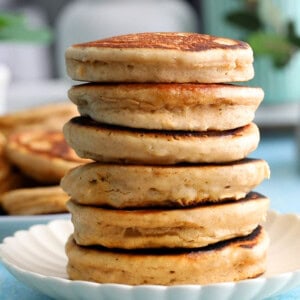 a tall stalk of almond butter pancakes in a white plate.