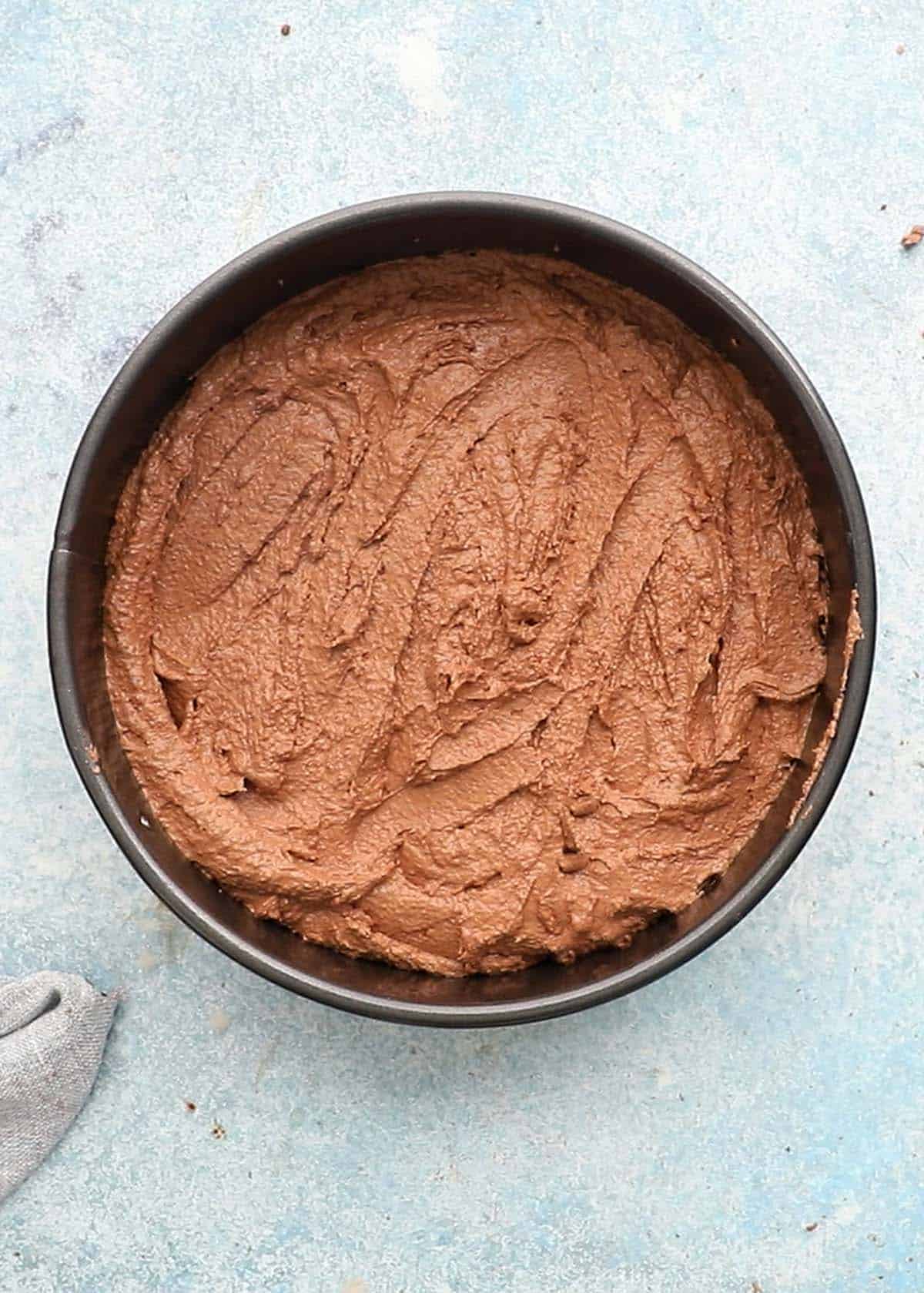 one round metal pan with brown cake batter.