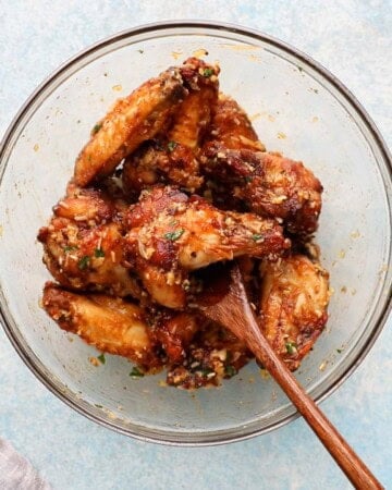 cooked brown chicken wings in a large glass bowl.
