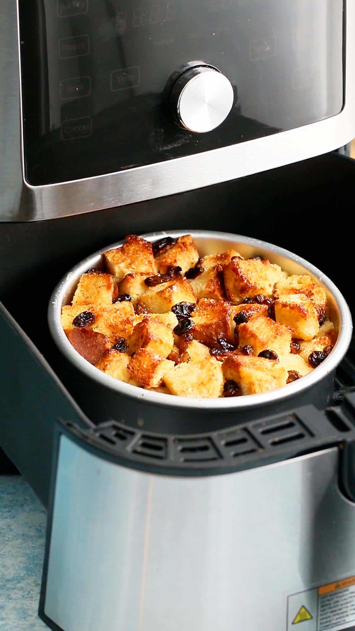 baked bread pudding in an air fryer basket.