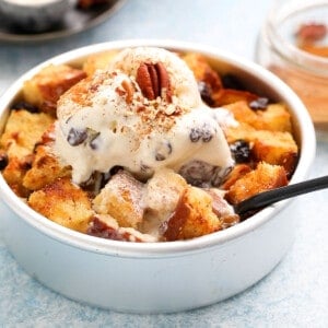 round metal cake pan with bread pudding topped with vanilla ice cream.