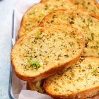 toasted garlic bread slices on a white tray.
