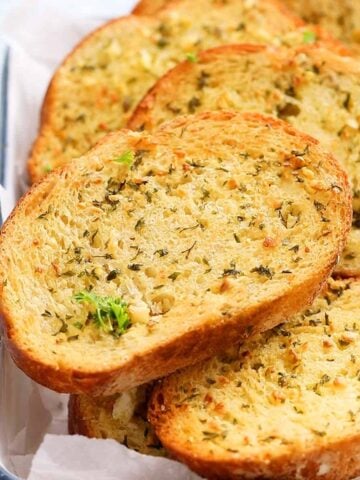 toasted garlic bread slices on a white tray.