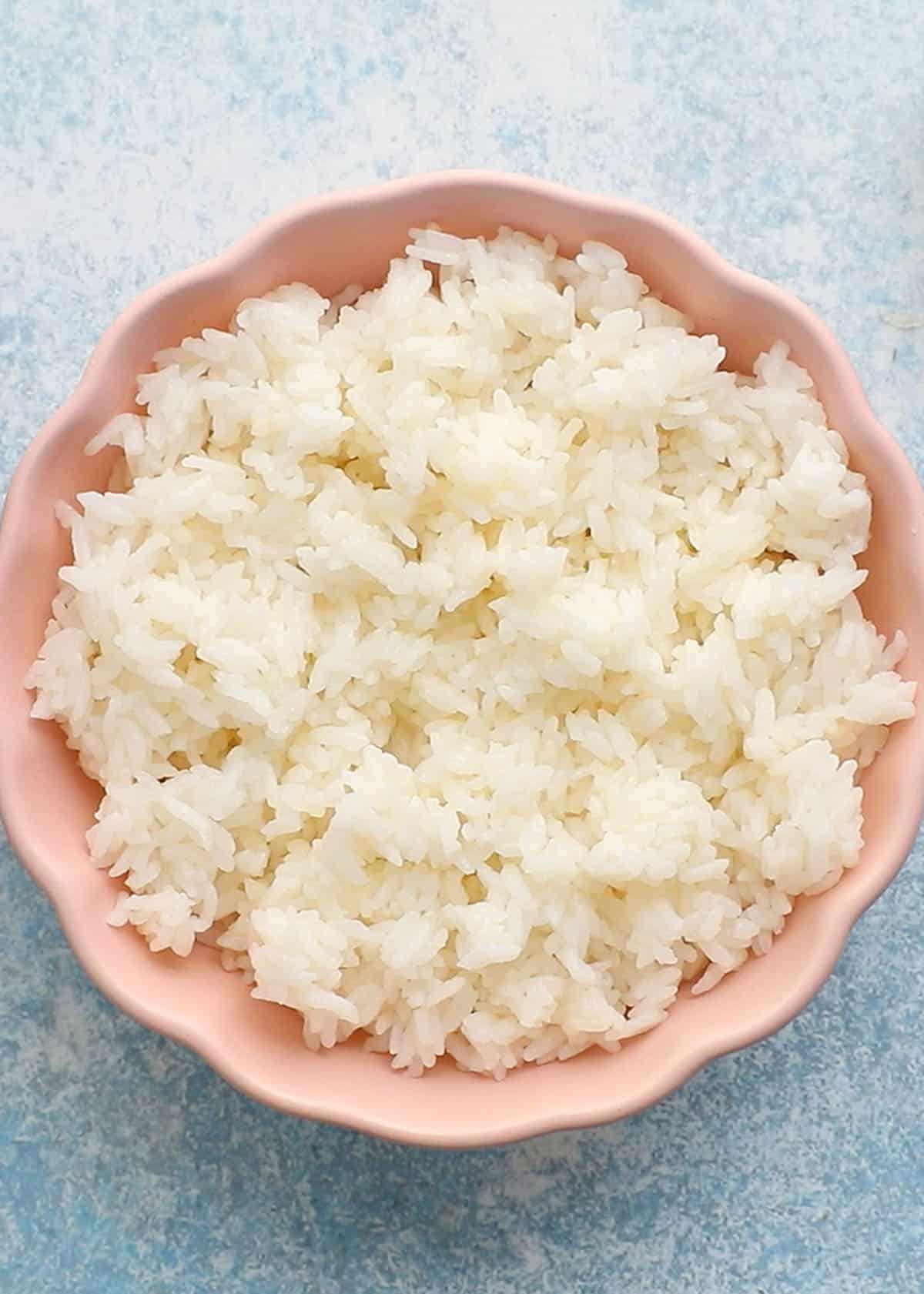cooked white rice in a pink bowl.