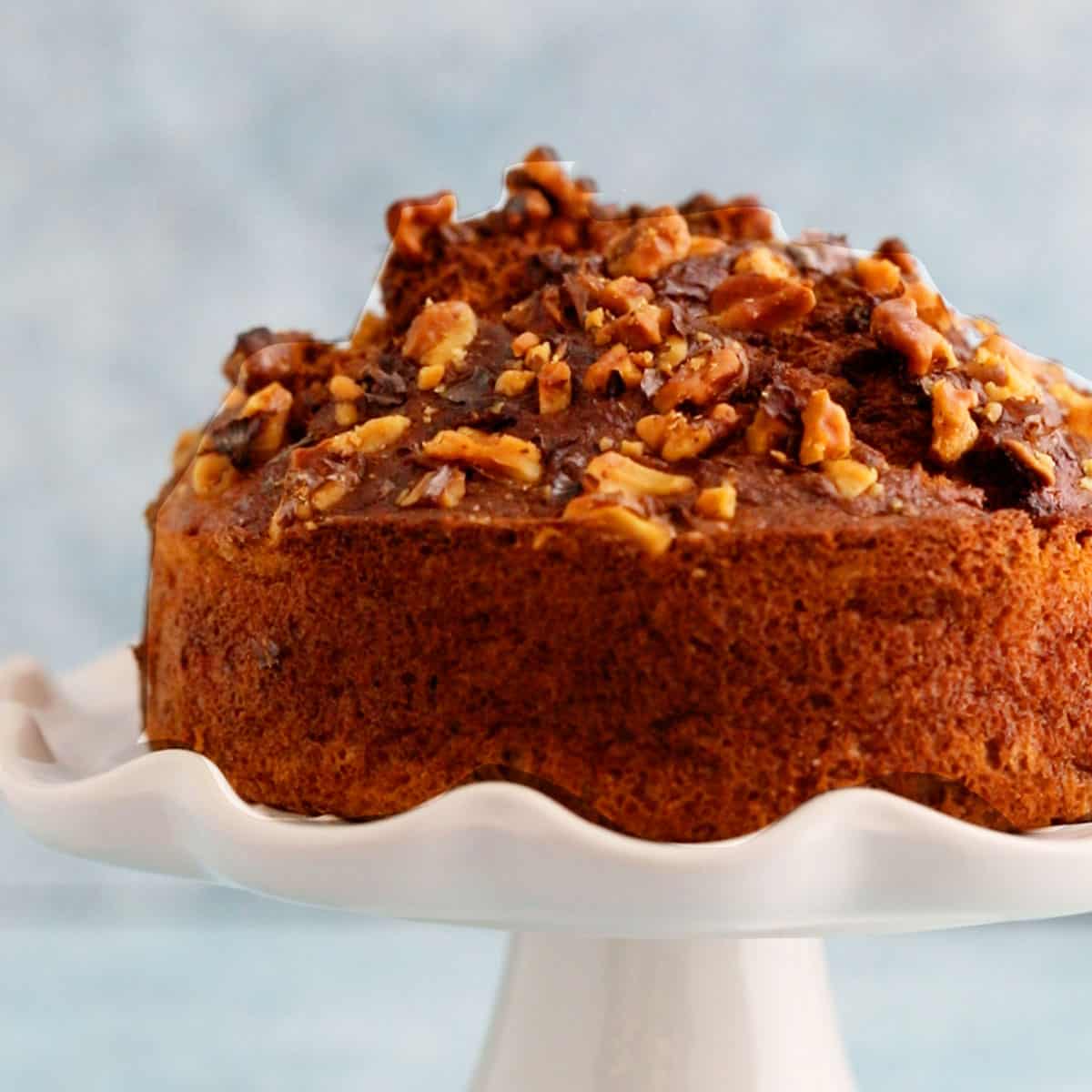 one air fryer banana cake placed on a white cake stand.