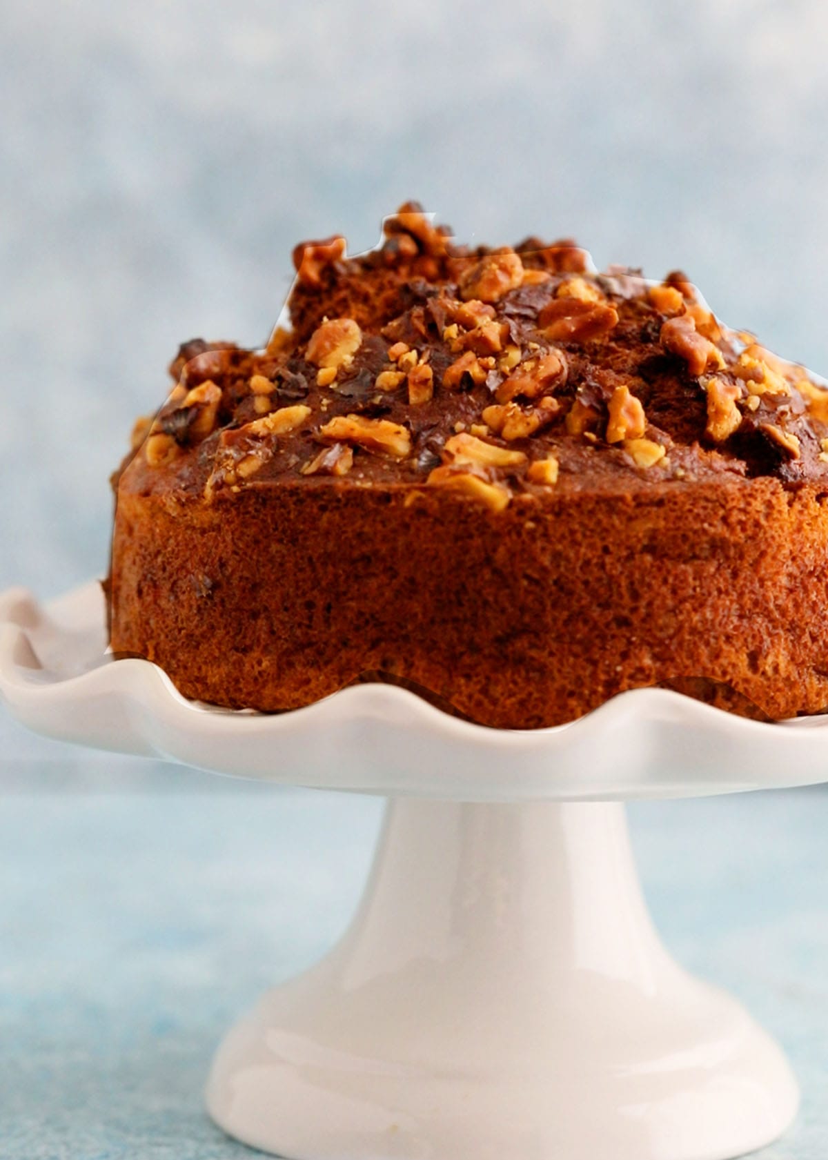 one air fryer banana cake placed on a white cake stand.