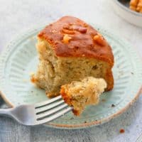 fork with a bite of soft banana cake with remaining slice