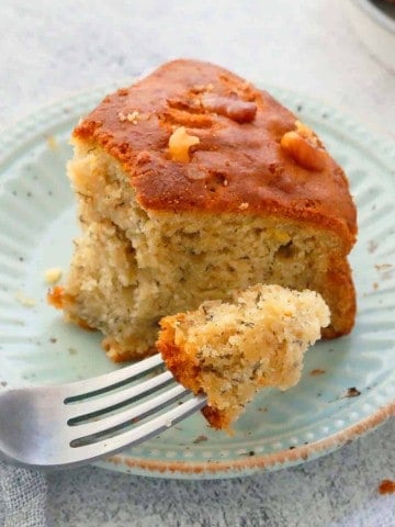 fork with a bite of soft banana cake with remaining slice