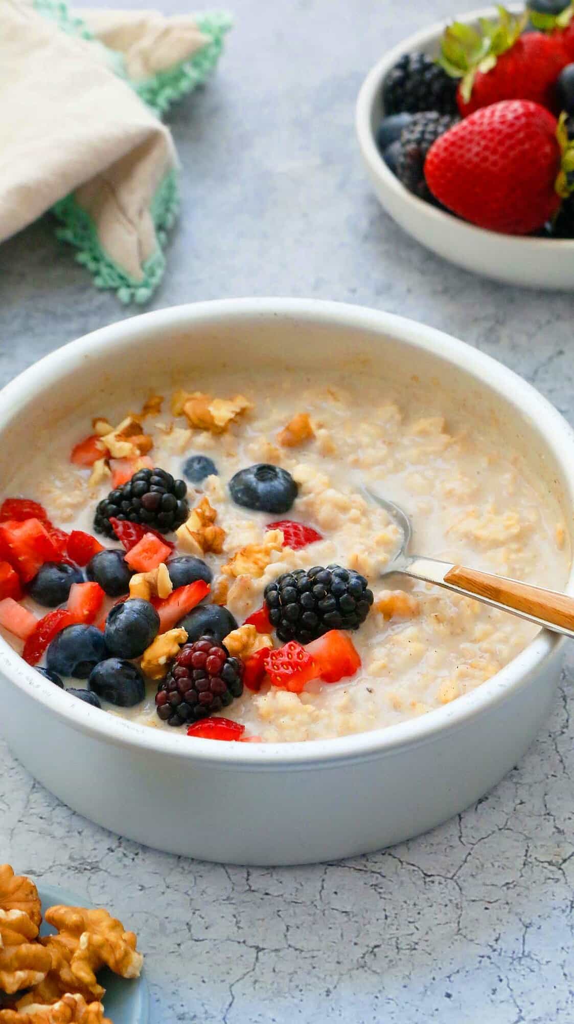 Oatmeal in a round pan with berries and walnuts