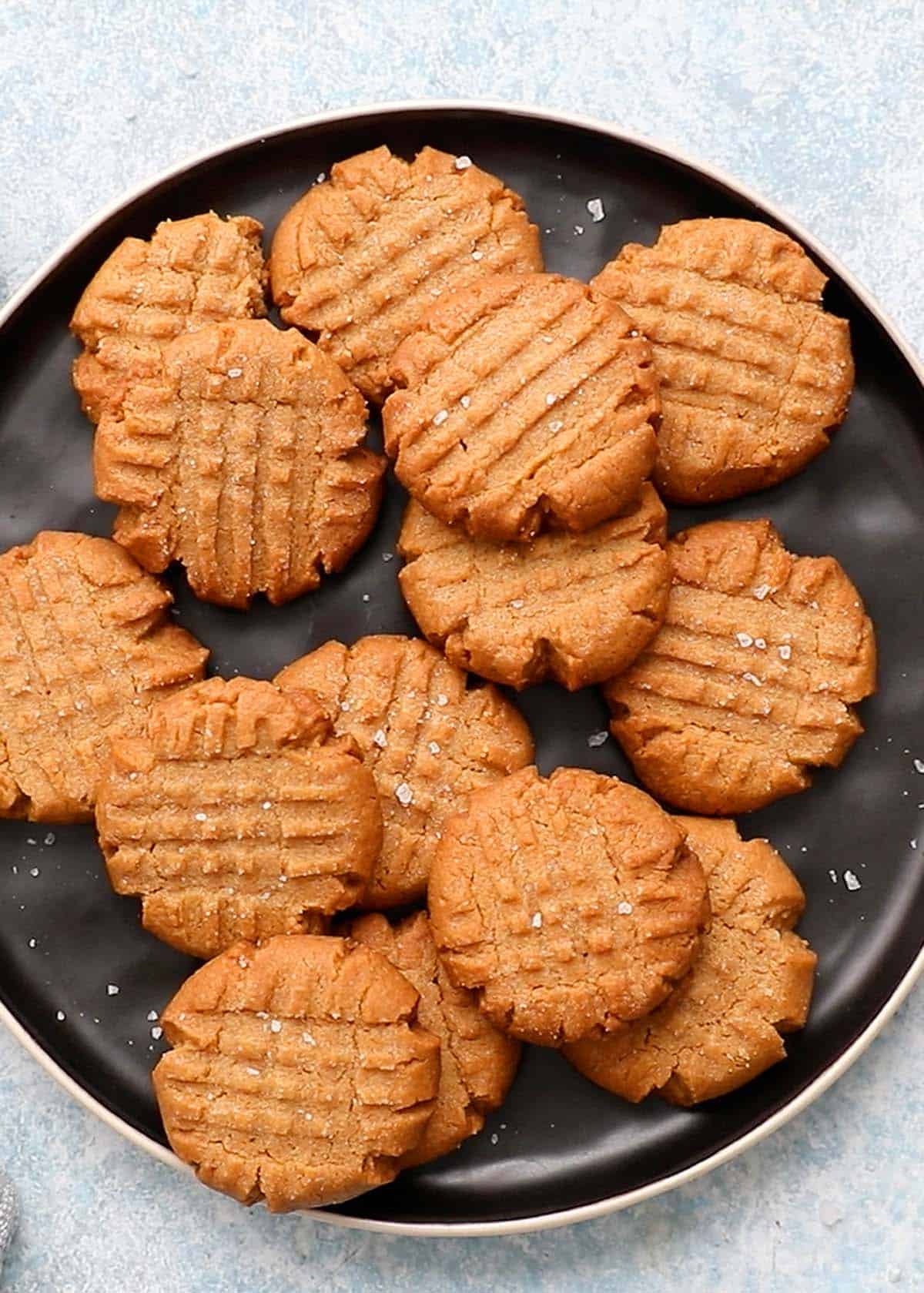 one round black plate filled with almond butter cookies.