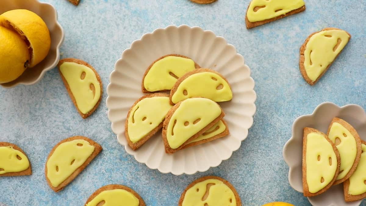 5 almond flour lemon cookies in a white fluted plate.
