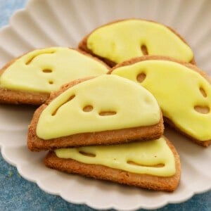 5 almond flour lemon cookies in a white fluted plate.