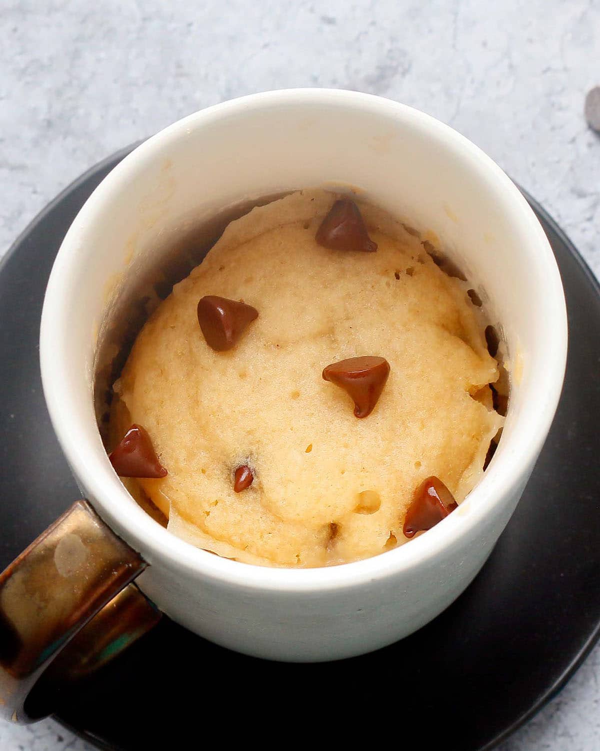 vanilla chocolate chip vegan mug cake in a white coffee mug.