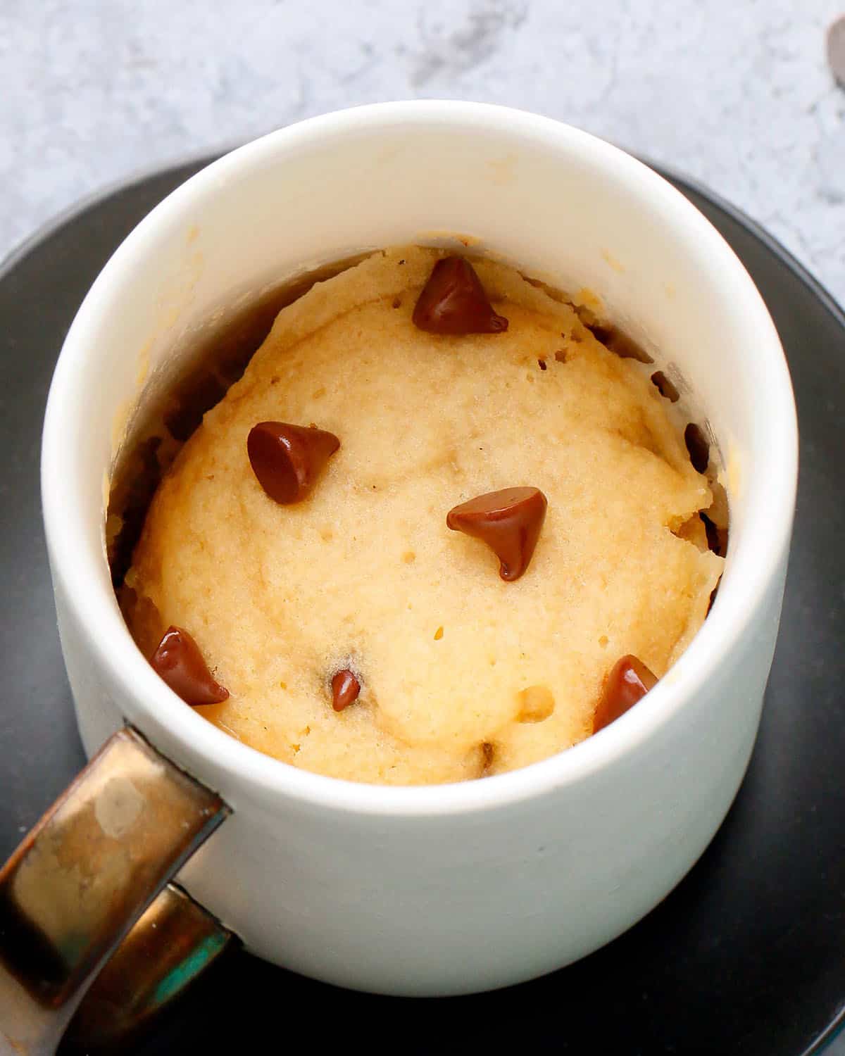 vanilla chocolate chip vegan mug cake in a white coffee mug.