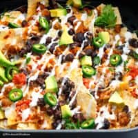 air fryer basket with cheesy nachos